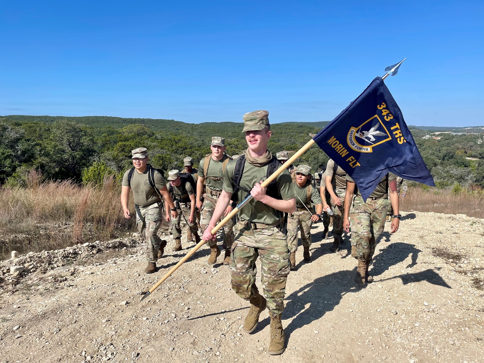 Airmen carry a guidon during the defender ruck