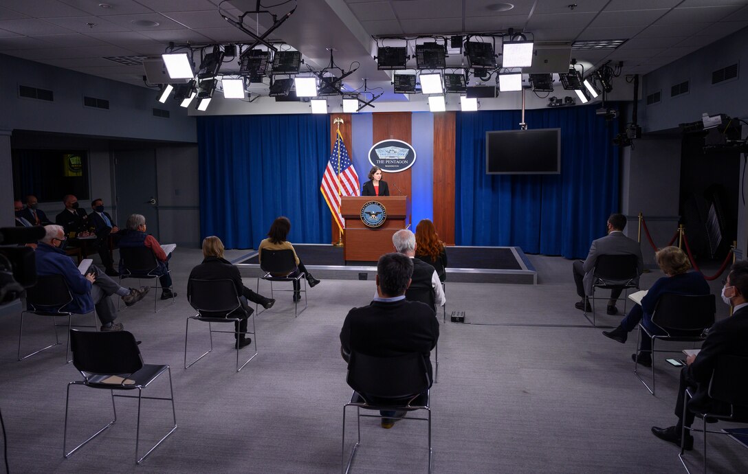 A woman briefs people in a Pentagon studio.
