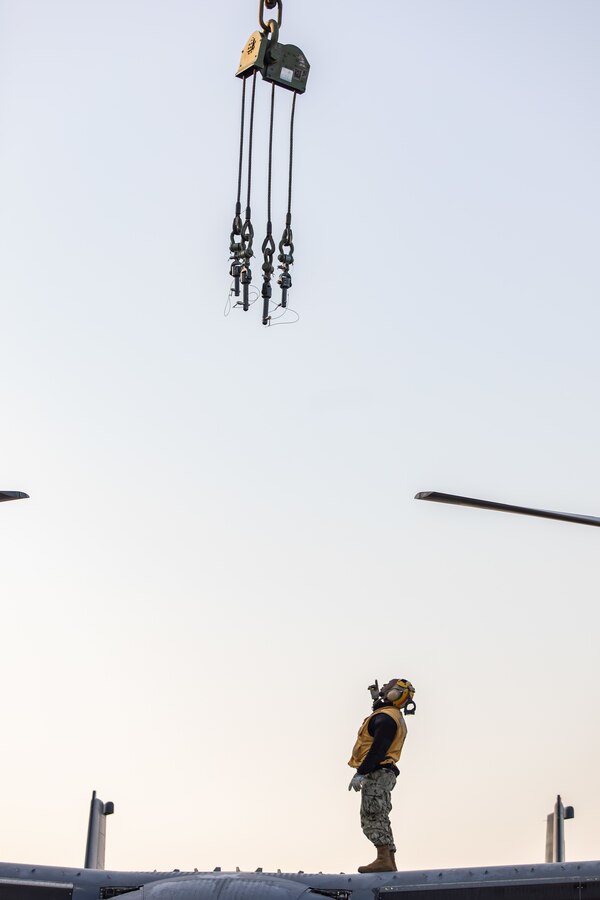 米海兵隊岩国航空基地で11月20日、CV-22オスプレイからクレーンに指示を出す港湾課所属の海軍隊員。このオスプレイは米海軍強襲揚陸艦「アメリカ（LHA6）」が岩国基地に停泊中、同揚陸艦に搭載された。岩国基地はその地理的位置と航空施設および港湾施設を併せ持つことから、地域の安全を支援し、先進の海軍・海兵隊統合を提供するという稀有な位置づけにある。（写真：フポン・ウェン伍長）