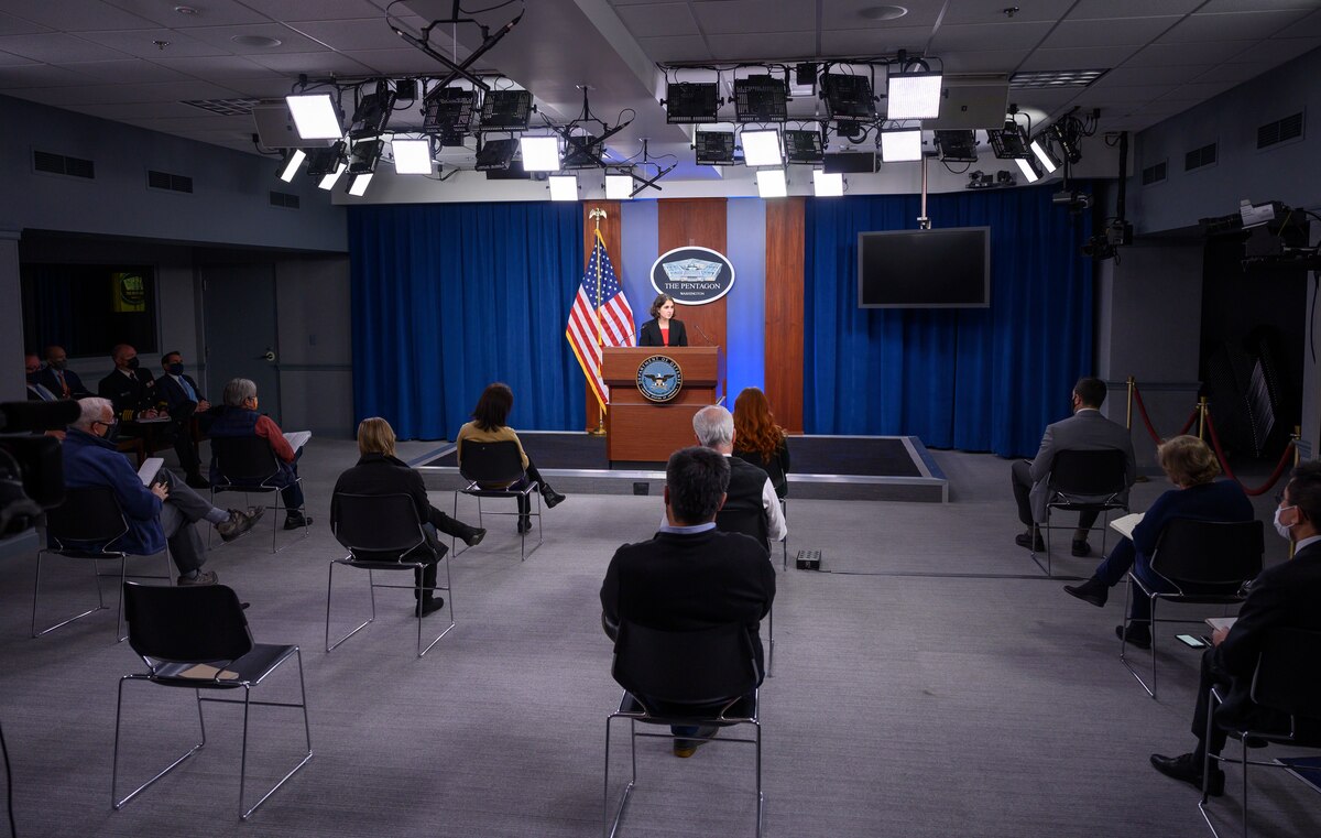 A woman briefs people in a Pentagon studio.