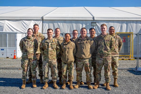 Airman 1st Class Kelsey Davis, 2nd Lt. Graeme Clark, Capt. Kurt Mann, Master Sgt. Derek Butori, Senior Airman Jayauna Tyler, Staff Sgt. Robert Stribling, 1st Lt. Zachary Harrell, Senior Airman Joash Mendoza-Castorillo, 2nd Lt. Taylor Ferry, and Tech. Sgt. David Jeetan, all Airmen from Hill Air Force Base, Utah, pose for a photo in Liberty Village on Joint Base McGuire-Dix-Lakehurst, New Jersey, Nov. 3, 2021. The Department of Defense, through U.S. Northern Command, and in support of the Department of Homeland Security, is providing transportation, temporary housing, medical screening, and general support for at least 50,000 Afghan evacuees at suitable facilities, in permanent or temporary structures, as quickly as possible. This initiative provides Afghan personnel essential support at secure locations outside Afghanistan. (U.S. Air Force photo by 2nd Lt. Hunter Dabbs)