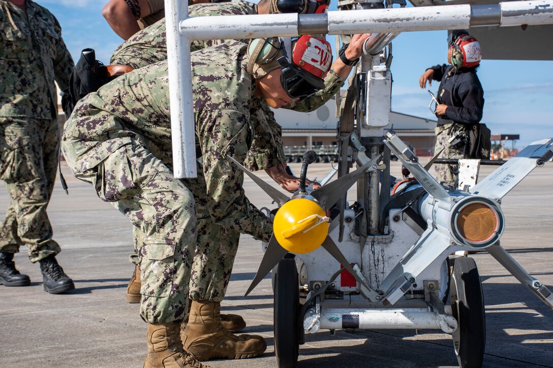 Several Ordnance members attached to Carrier Air Wing 17 prepare to lift and load an AIM-9 Sidewinder before a live-fire mission at Tyndall AFB, Fla., Nov. 10, 2021. WSEP tests and validates the performance of crews, pilots, and their technology to enhance readiness for real-world operations. (U.S. Air Force photo by 1st Lt Lindsey Heflin)