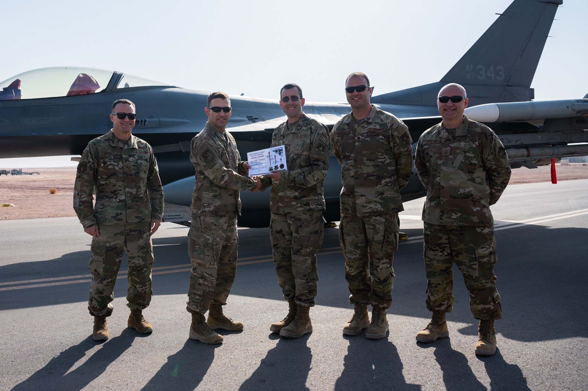 Tech. Sgt. Jeremy Rasmussen, 176th Expeditionary Fighter Squadron aircraft electrical and environmental systems specialist, receives a superior performer certificate from Brig. Gen. Robert Davis, 378th Air Expeditionary Wing commander, at Prince Sultan Air Base, Kingdom of Saudi Arabia, Nov. 23, 2021. Rasmussen was recognized for his superior performance in Iron Falcon 2021, a bilateral training exercise with Saudi coalition partners. (U.S. Air Force photo by Senior Airman Jacob B. Wrightsman)