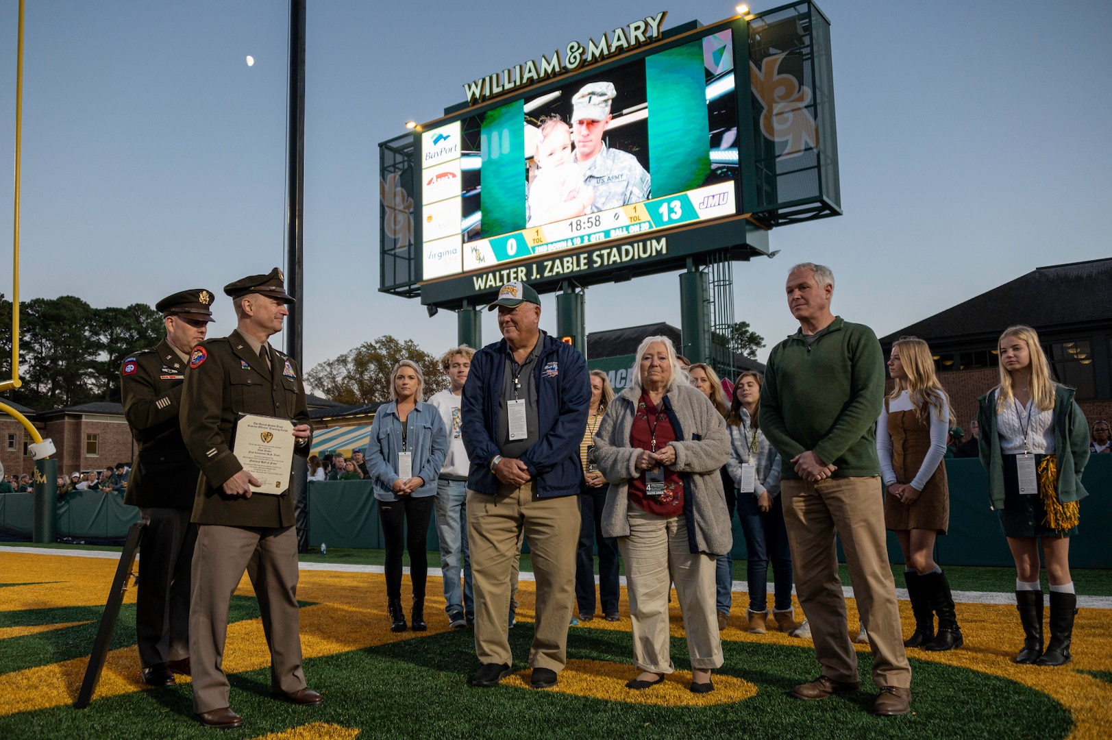 First Lt. Todd W. Weaver is inducted into the Army ROTC Hall of Fame during a military appreciation football game Nov. 13, 2021, at the College of William and Mary. Weaver started his military career in the Virginia National Guard before transitioning to active duty and was killed in action during a night ambush operation in Afghanistan Sept. 9, 2010. Brig. Gen. James W. Ring, Director of the Joint Staff for the Virginia National Guard, presided over the induction ceremony and recognized Weaver’s family on the field. Virginia National Guard cannon crews assigned to the Hanover-based Alpha Battery, 1st Battalion, 111th Field Artillery Regiment, 116th Infantry Brigade Combat Team and UH-60 Black Hawk helicopters assigned to the Sandston-based 2nd Battalion, 224th Aviation Regiment, 29th Infantry Division supported the event with cannon fire and a flyover. (U.S. Army National Guard Photo by Staff Sgt. Lisa M. Sadler)