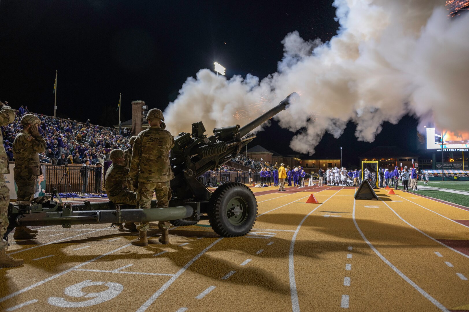 First Lt. Todd W. Weaver is inducted into the Army ROTC Hall of Fame during a military appreciation football game Nov. 13, 2021, at the College of William and Mary. Weaver started his military career in the Virginia National Guard before transitioning to active duty and was killed in action during a night ambush operation in Afghanistan Sept. 9, 2010. Brig. Gen. James W. Ring, Director of the Joint Staff for the Virginia National Guard, presided over the induction ceremony and recognized Weaver’s family on the field. Virginia National Guard cannon crews assigned to the Hanover-based Alpha Battery, 1st Battalion, 111th Field Artillery Regiment, 116th Infantry Brigade Combat Team and UH-60 Black Hawk helicopters assigned to the Sandston-based 2nd Battalion, 224th Aviation Regiment, 29th Infantry Division supported the event with cannon fire and a flyover. (U.S. Army National Guard Photo by Staff Sgt. Lisa M. Sadler)