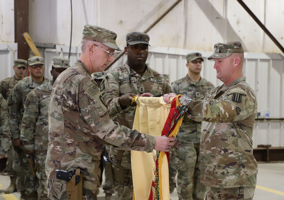 Col. Todd Pegg, 329th Regional Support Group outgoing commander, cases the 329th RSG colors during a transfer of authority ceremony Nov. 23, 2021, at Al Asad Air Base, Iraq. The transfer officiated the unit’s downgrade at the base from an O-6 command to a O-5 command, which is a demonstrative step towards Combined Joint Task Force Operation Inherent Resolve’s advise, assist, and enable phase. (U.S. Army photo by Maj. Alexa Carlo-Hickman)