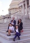 Senior Chief Petty Officer Anitra Keith (far right), sits with her family in front of the Capital in Washington, D.C., with her husband Jason (far left) and their daughters: Aleesa, 10 (on the right) and Della, eight (on the left). Jon, their adopted 18-month-old son, sits on his father’s lap.  Photo courtesy Senior Chief Petty Officer Anitra Keith.