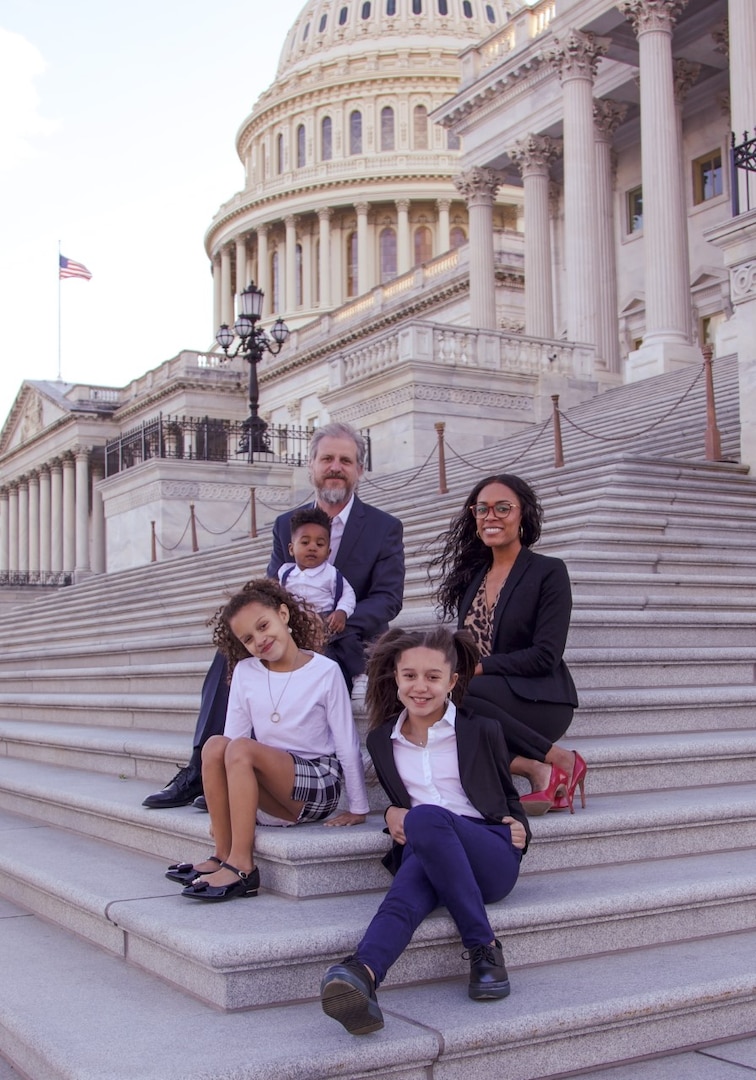 Senior Chief Petty Officer Anitra Keith (far right), sits with her family in front of the Capital in Washington, D.C., with her husband Jason (far left) and their daughters: Aleesa, 10 (on the right) and Della, eight (on the left). Jon, their adopted 18-month-old son, sits on his father’s lap.  Photo courtesy Senior Chief Petty Officer Anitra Keith.