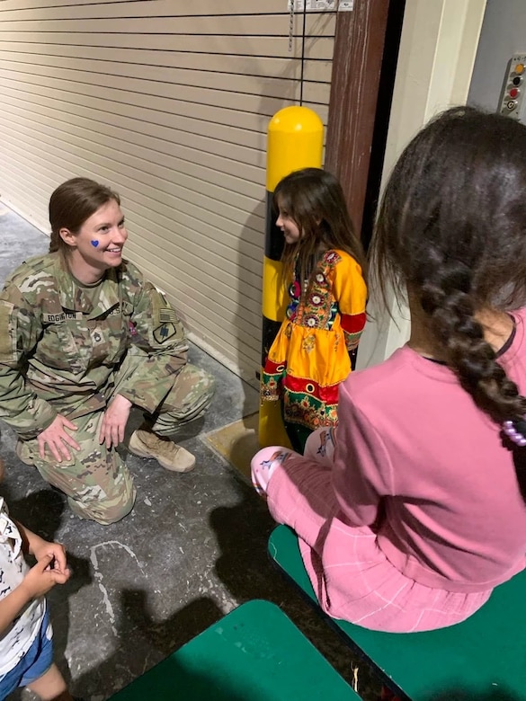 Sgt. 1st Class Nicole Edgington, the Task Force Liberty Civil Affairs Noncommissioned-Officer-in-Charge, shares a moment with one of Muhammed's daughters during the family's stay at Camp As Sayliyah, Qatar, before they flew to America. Now settled, the family sent Edgington a video recently, in which Muhammed thanked Task Force Liberty Soldiers and civilians for the work they put in to assist his, along with thousands of other families, reach safety. (Courtesy photo)