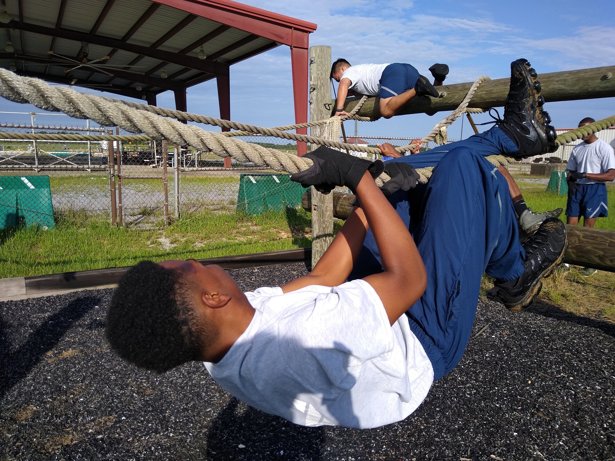 Members of the 908th Airlift Wing, 25th Aerial Port Squadron, negotiate their way across an obstacle at the U.S. Air Force Officer Training School’s “Project X” on Maxwell Air Force Base, Ala., July 10. The event was a team-building and morale-boosting exercise which challenged participants’ problem-solving skills as well as physical fitness. (U.S. Air Force photo by Chief Master Sgt. Tracey Piel)