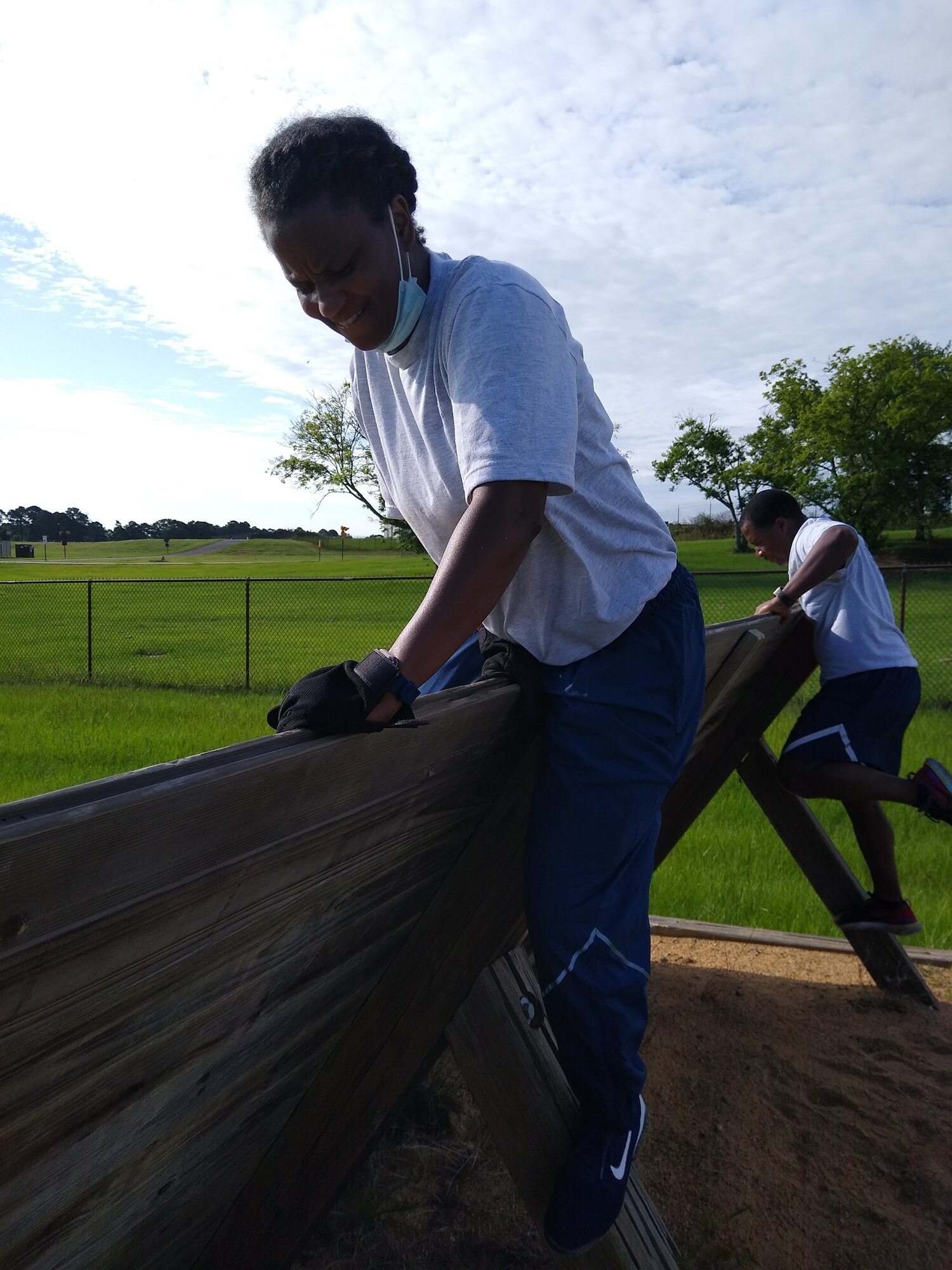 Master Sgt. Kristy McGrue and Tech. Sgt. Zaccaeus Chames, 908th Airlift Wing, 25th Aerial Port Squadron, negotiate their way over an obstacle at the U.S. Air Force Officer Training School’s “Project X,” on Maxwell Air Force Base, Ala., July 10. The event was a team-building and morale-boosting exercise which challenged participants’ problem-solving skills as well as physical fitness. (U.S. Air Force photo by Chief Master Sgt. Tracey Piel)