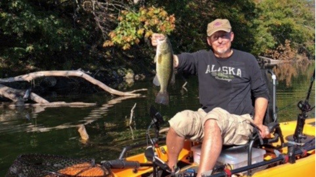 a man holding a fish on a boat