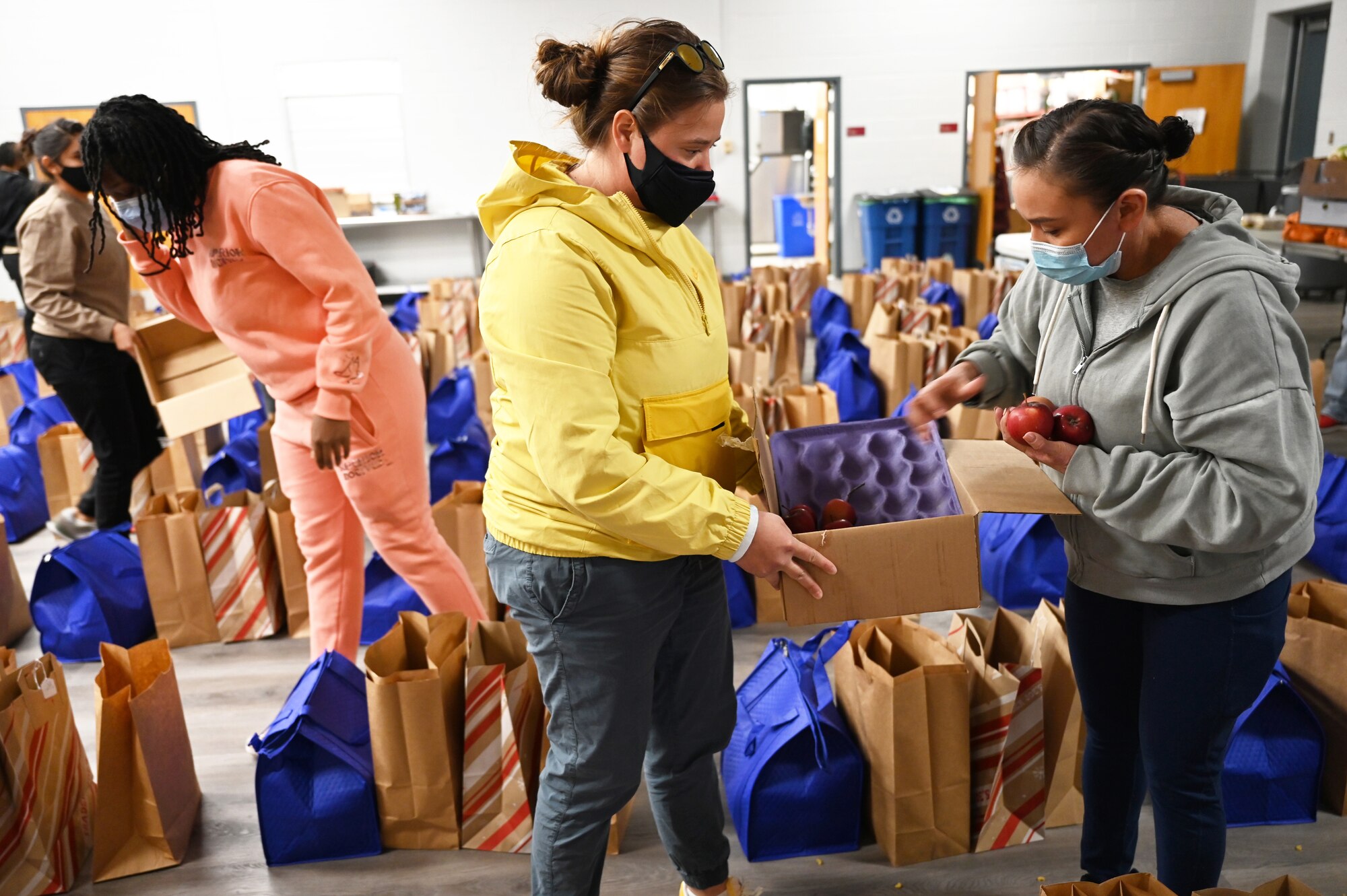 Volunteers fill food bags in the chapel at Joint Base Anacostia-Bolling, Washington, D.C., Nov. 19, 2021. A group of more than 50 volunteers made up of U.S. Airmen, Sailors, and base and local community volunteers joined forces to support the chapel and first sergeant association holiday charitable food drive. Volunteers packed bags with frozen chickens and turkeys, pasta, apple cider, fresh vegetables, and canned foods and distributed them to military families on base. (U.S. Air Force photo by Benjamin Matwey)