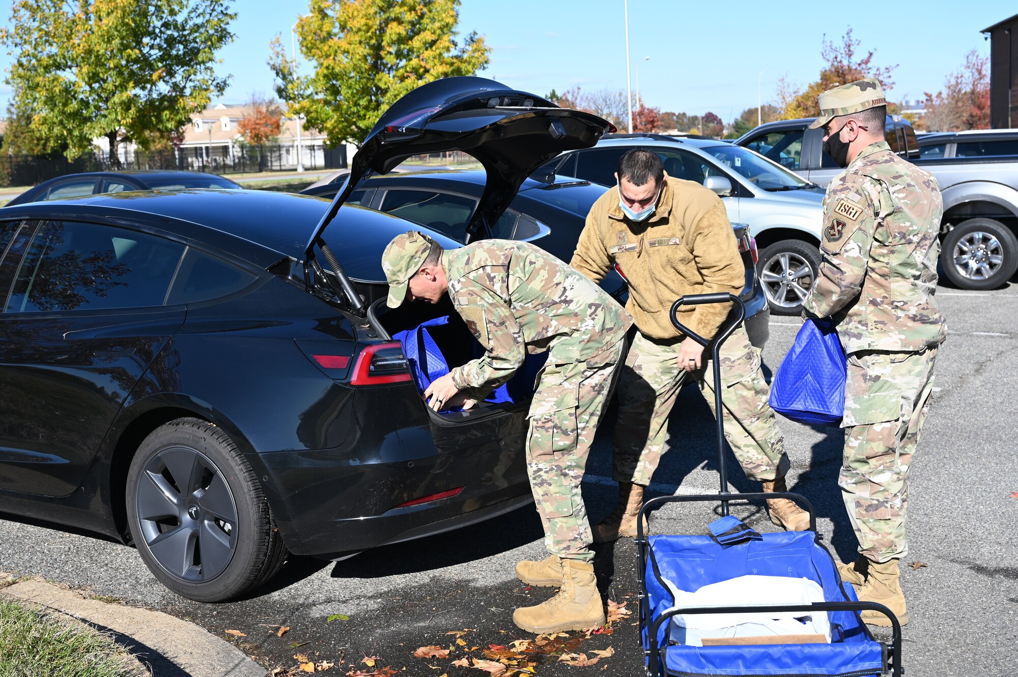 Air Force Chaplain (1st Lt.) Joshua Zarzana, left; Staff Sgt. Ryan Vega, 11th Wing religious affairs Airman; and Senior Master Sgt. Mohammed Abouhashem, United States Honor Guard first sergeant, load food outside the chapel at Joint Base Anacostia-Bolling, Washington, D.C., Nov. 19, 2021. A group of more than 50 volunteers made up of U.S. Airmen, Sailors, and base and local community volunteers joined forces to support the chapel and first sergeant association holiday charitable food drive. Volunteers packed bags with frozen chickens and turkeys, pasta, apple cider, fresh vegetables, and canned foods and distributed them to military families on base. (U.S. Air Force photo by Benjamin Matwey)