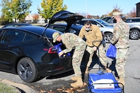 Air Force Chaplain (1st Lt.) Joshua Zarzana, left; Staff Sgt. Ryan Vega, 11th Wing religious affairs Airman; and Senior Master Sgt. Mohammed Abouhashem, United States Honor Guard first sergeant, load food outside the chapel at Joint Base Anacostia-Bolling, Washington, D.C., Nov. 19, 2021. A group of more than 50 volunteers made up of U.S. Airmen, Sailors, and base and local community volunteers joined forces to support the chapel and first sergeant association holiday charitable food drive. Volunteers packed bags with frozen chickens and turkeys, pasta, apple cider, fresh vegetables, and canned foods and distributed them to military families on base. (U.S. Air Force photo by Benjamin Matwey)