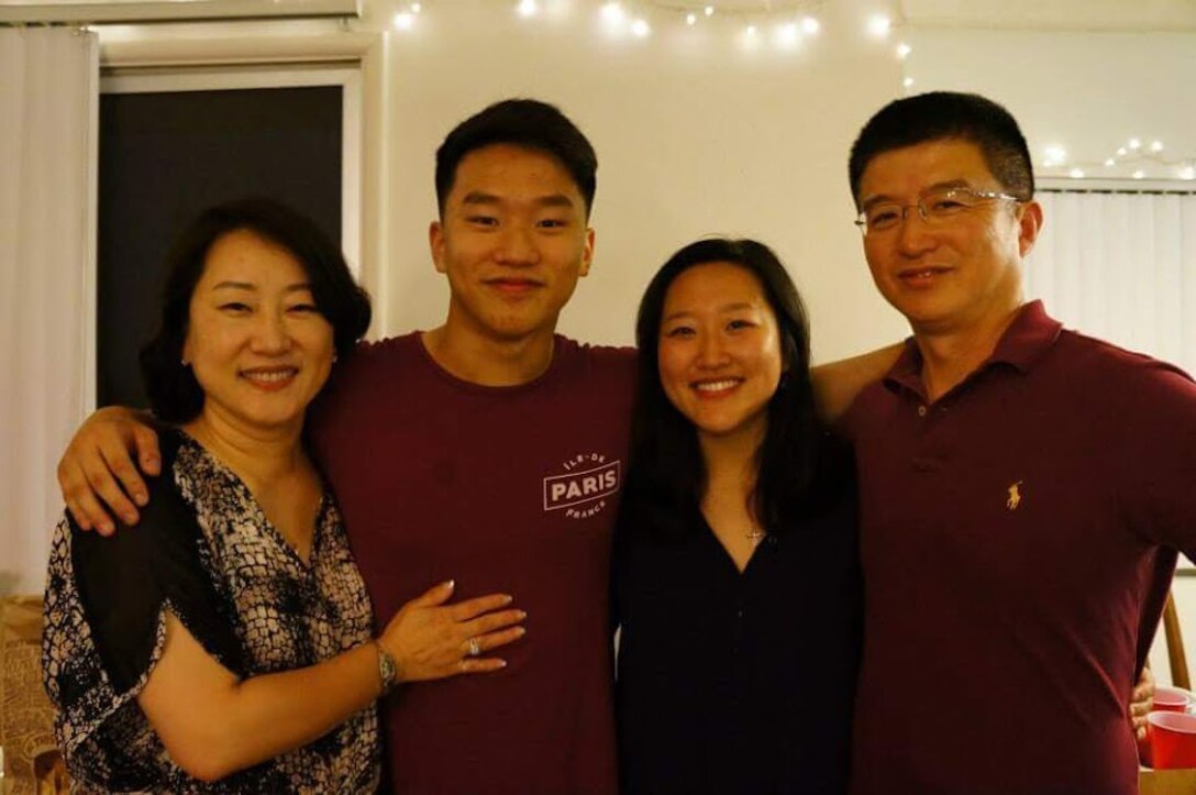 A family of four poses for a photo.