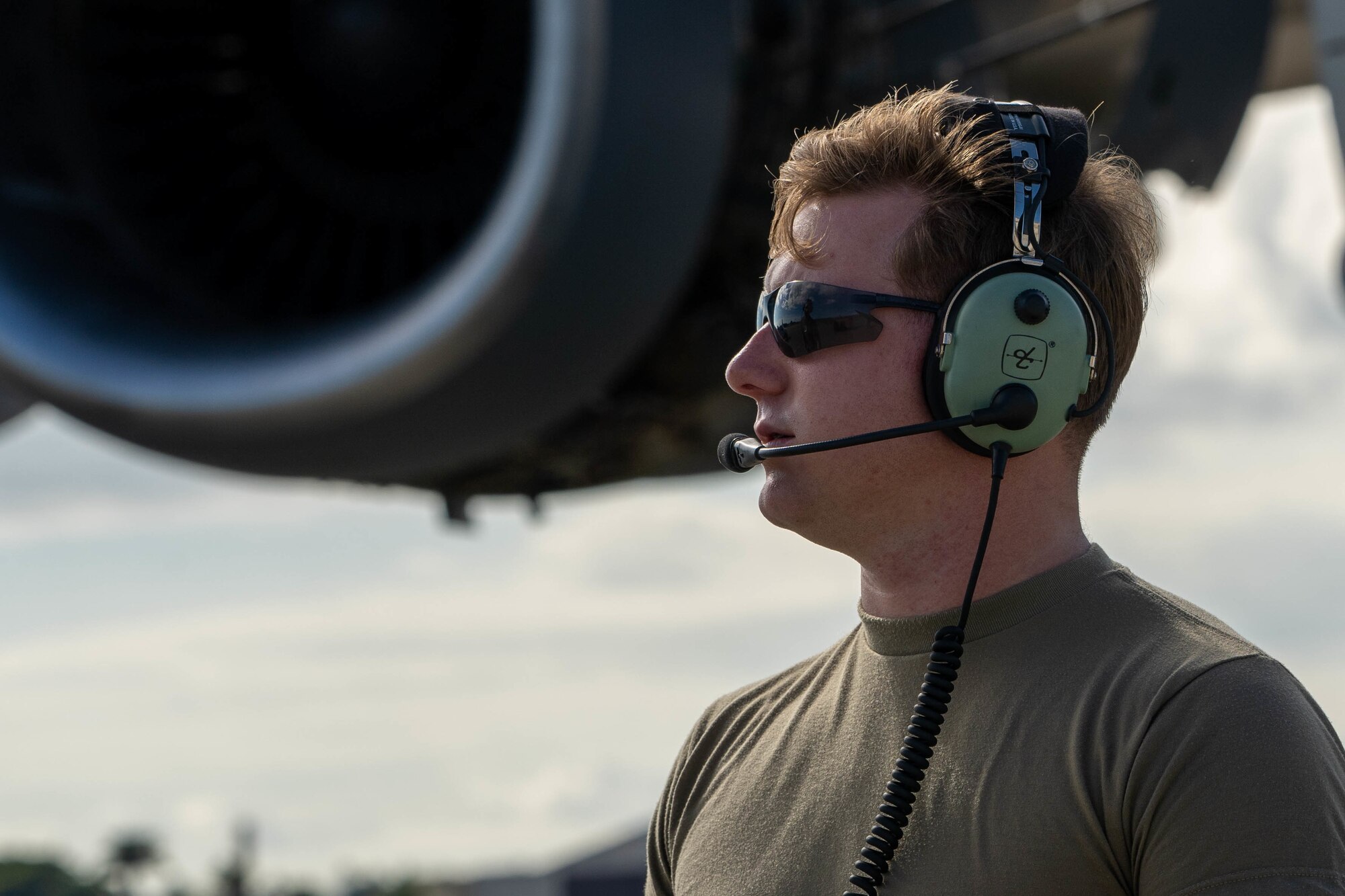 Senior Airman Sean Ryan, 15th Maintenance Squadron, aerospace propulsion journeyman communicates with a C-17 Globemaster III aircrew during an eco-wash at Joint Base Pearl Harbor-Hickam, Hawaii, November 18, 2021. C-17’s engines routinely receive this wash to prevent corrosion and to help with fuel efficiency. (U.S. Air Force photo by Airman 1st Class Makensie Cooper)