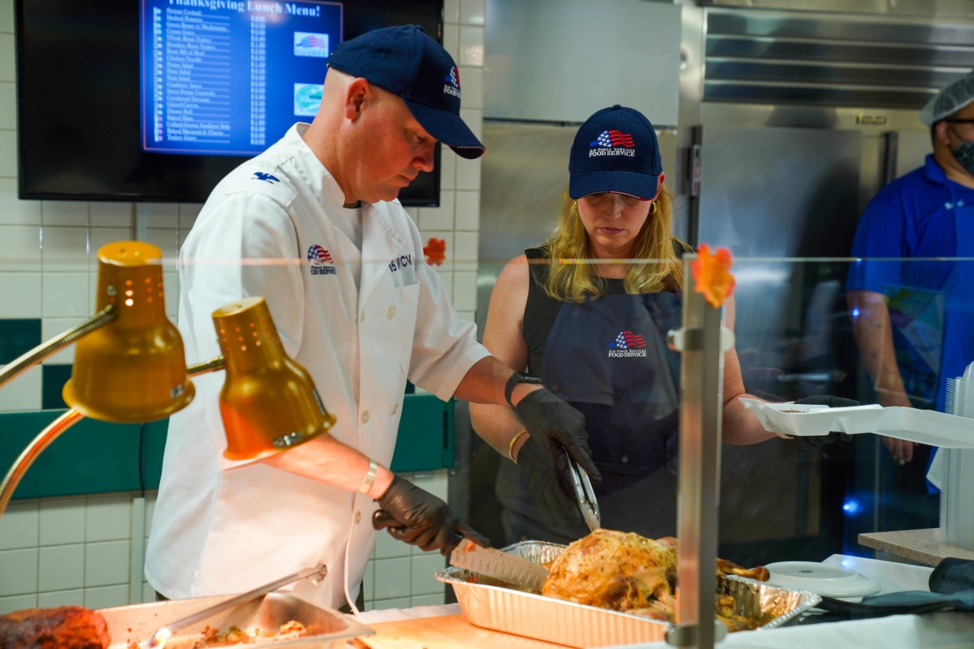 Col. Robert Brown, 15th Wing vice commander and his wife Jane Brown carve the turkey at the Hale Aina Dining Facility, November 25, 2021. Leaders from Joint Base Pearl Harbor-Hickam served airmen and their families lunch on Thanksgiving. (U.S. Air Force photo by Airman 1st Class Makensie Cooper)