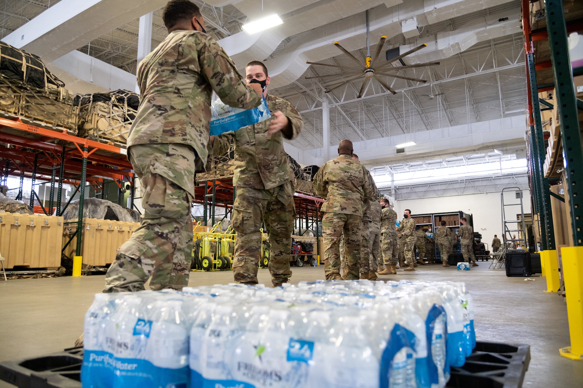 U.S. Airmen assigned to the 621st Contingency Response Wing move water bottles into storage containers to make more space Oct. 8, 2021, at Joint Base McGuire-Dix-Lakehurst, New Jersey. The 621st Contingency Response Wing is accelerating change by adding another CR squadron to the 821st Contingency Response Group at Travis Air Force Base, California, and the 621st CRG at JBMDL. (U.S. Air Force photo by Staff Sgt. Sarah Brice)