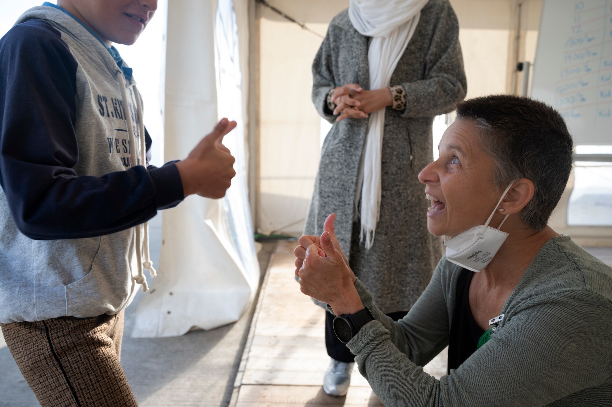 Catherine Ilic, a transition workshop instructor, gives a thumbs up to an evacuee from Afghanistan at Ramstein Air Base Germany, Sept. 30, 2021. Ilic and others are teaching children classroom etiquette because many of them are unfamiliar with an American classroom environment. (U.S. Air Force photo by Senior Airman Thomas Karol)