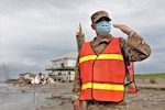Mississippi National Guard 2nd Lt. Austin Riels, assigned to the 113th Military Police Company, 112th Military Police Battalion, waves vehicles through a traffic control point after Hurricane Ida, Grand Isle, Louisiana, Sept. 17, 2021.