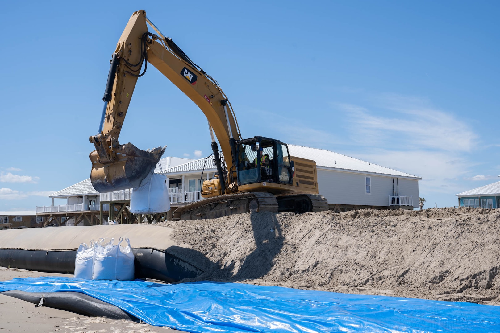 Louisiana National Guardsmen assigned to the 225th Engineer Brigade emplace 3-by-3 foot sacks filled with up to 4,000 pounds of sand each along 12 levee breaches, Grand Isle, La., Sept 24, 2021. Tidal surge from Hurricane Ida damaged the island’s levee leading to massive flooding.