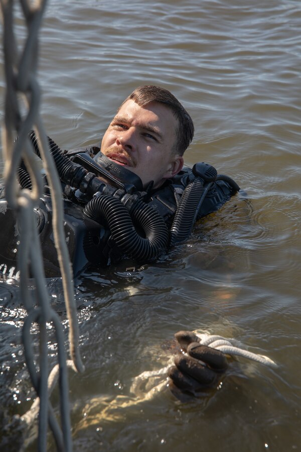 U.S. Marine Corps Sgt. Shane Franzen, a combatant diver with 3d Force Reconnaissance Company, 4th Marine Division, Marine Forces Reserve, prepares to climb aboard a rigid-hull inflatable boat during dive training in Mobile, Alabama, Sept. 25, 2021. Dive training enables the Marines with 3d Force Reconnaissance Co. to maintain and improve their diving skills as well as building confidence in themselves and their gear. (U.S. Marine Corps photo by Cpl. Brendan Mullin)