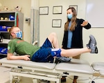 Research assistant, Kayla Enochs, directs BACH physical therapist Dr. Lee Webb, to raise his leg during a physical therapy session demonstrating exercises performed by Soldiers enrolled in a research study at BACH.