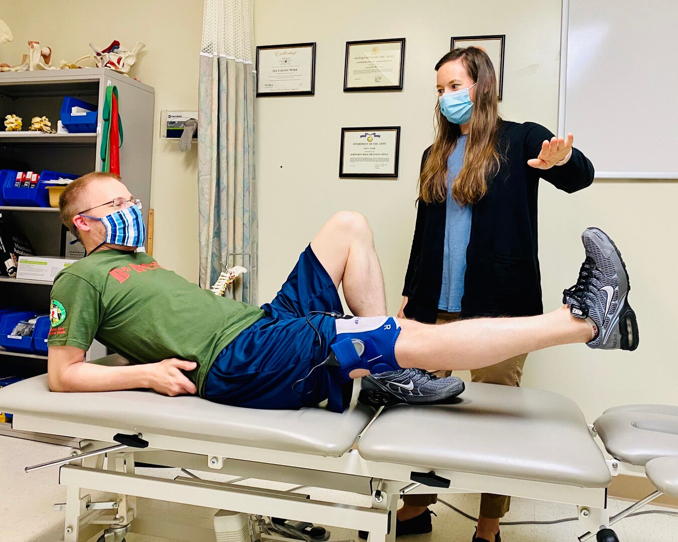 Research assistant, Kayla Enochs, directs BACH physical therapist Dr. Lee Webb, to raise his leg during a physical therapy session demonstrating exercises performed by Soldiers enrolled in a research study at BACH.