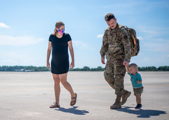 An Airman from the 6th Maintenance Group (MXG) walks with his family after returning home from deployment at MacDill Air Force Base, Florida, Sept. 27, 2021.