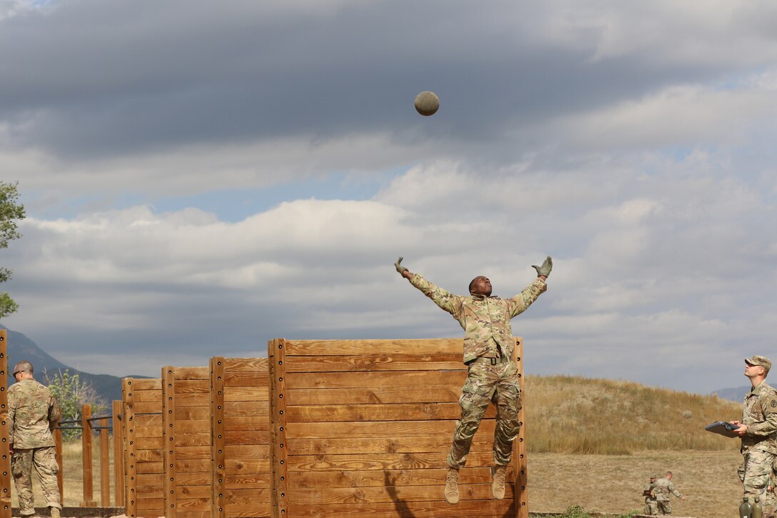 A soldier jumps in the air while looking up at a large ball.