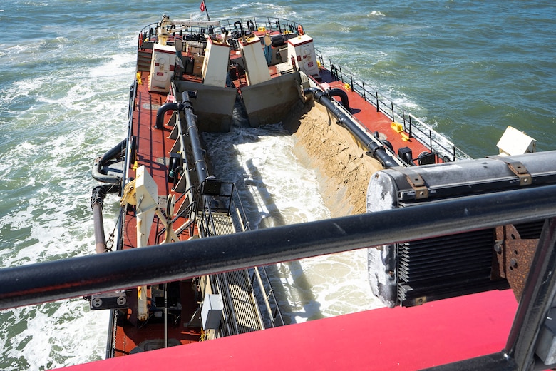 U.S. Army Corps of Engineers, Wilmington District’s, Hopper Dredge MURDEN places material during beach replenishment procedures as part of 24/7 dredge operations near an inlet in Ocean City, Md., Sept. 20, 2021. Beach Replenishment is a soft armoring technique that involves pumping sand onto an eroding shoreline to widen the existing beach. While this does not prevent erosion, it can reduce storm damage to coastal development and infrastructure. (U.S. Army photo by Greg Nash)