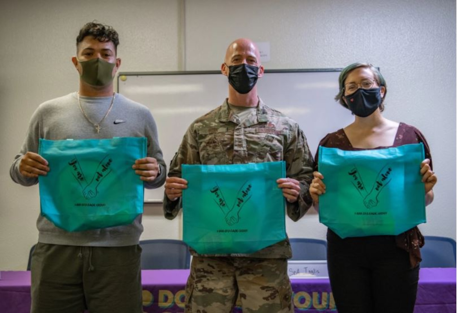 Participants in the Storytellers event at Kadena Air Base, Japan, pose for a photo after sharing their experiences, Sept. 9, 2021. After the event, those in attendance received gift bags with resources like a pocket journal, local crisis resource directory and a Mental Health Peer Alliance bookmark. (U.S. Air Force photo by Airman 1st Class Anna Nolte)