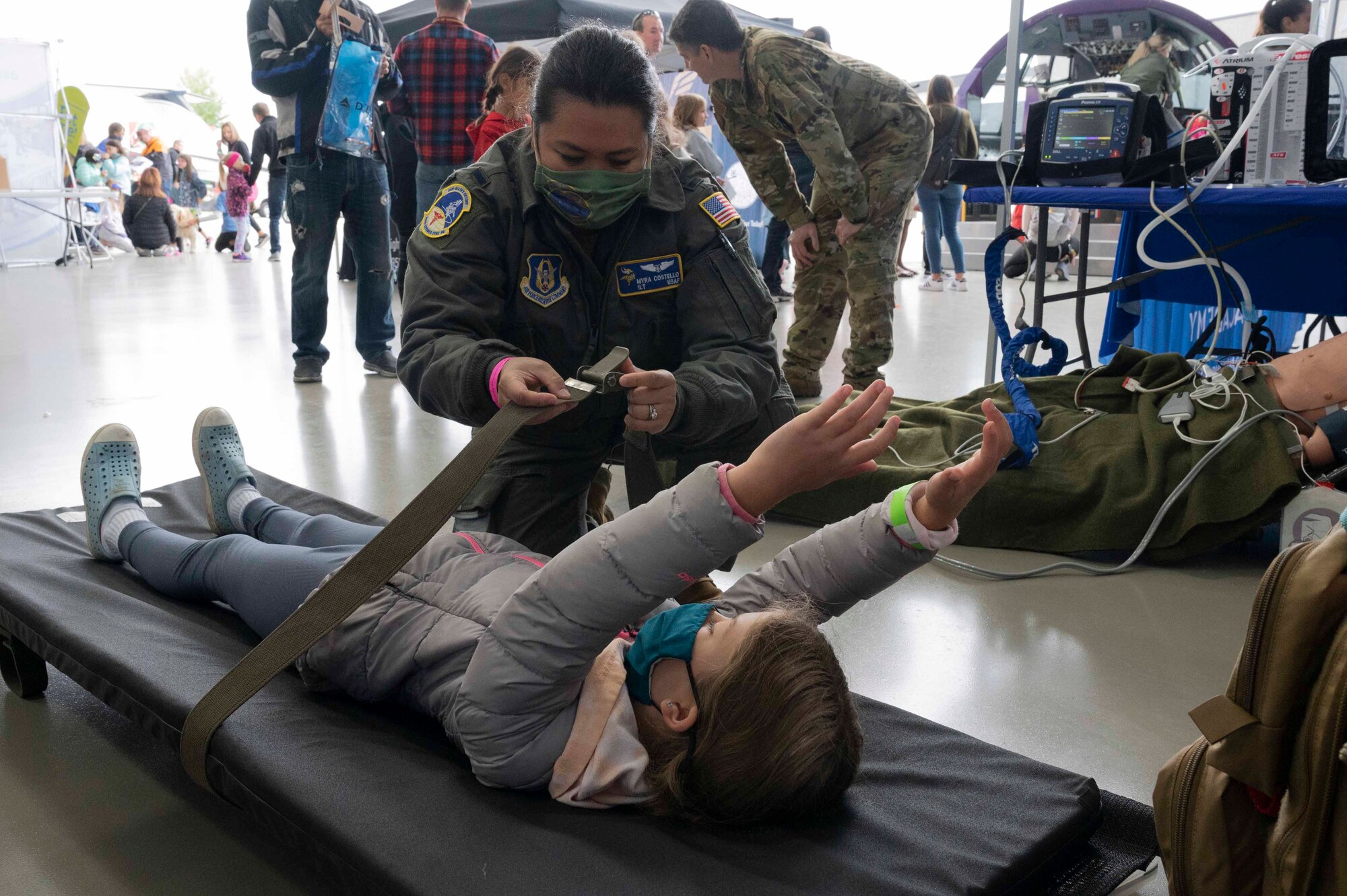 1st Lt. Myra Costello, 934th Aeromedical Evacuation Squadron, shows a young girl how patients are secured on a stretcher at the 7th Annual Girls in Aviation Day hosted by the Women in Aviation International at the Flying Cloud Airport in Eden Prairie, Minn., on Sept. 25, 2021. After the 2020 event was cancelled due to the COVID-19 pandemic, participating in this year’s event was something the wing’s Reserve Citizen Airmen looked forward to.