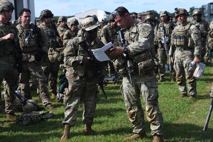 U.S. Army Soldiers assigned to the 82nd Airborne Division, Pope Army Airfield, N.C., receive a brief before loading onto a bus headed to board a C-17 Globemaster III at Joint Base Charleston, S.C.