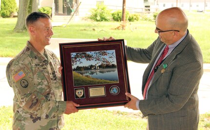 Col. John “Ryan” Bailey, left, commander of the U.S. Army Medical Materiel Agency, presents Chris Roan with a gift during his retirement ceremony Sept. 17 at Fort Detrick, Maryland. Roan retires with nearly 40 years of federal service.