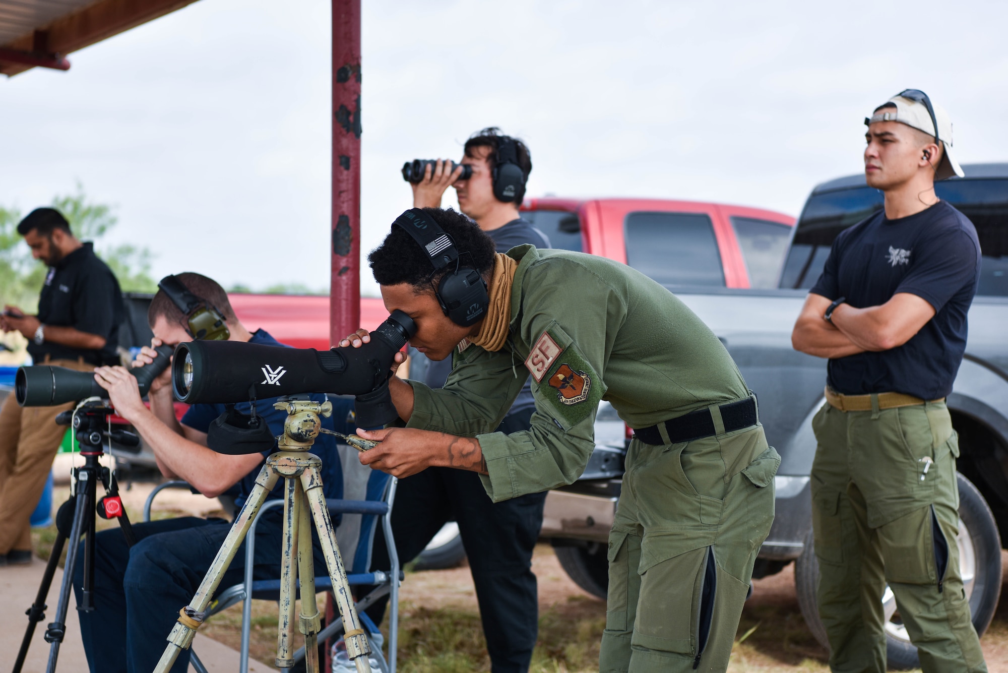 U.S. Air Force Senior Airman Emmanuel Parrott, 17th Security Forces Squadron emergency communication center defender, spots a target for a teammate during the joint marksmanship training course at the San Angelo Police Department firing range in San Angelo, Texas, Sept. 29, 2021. Spotters were tasked with tracking rounds and providing corrections to improve the accuracy of their teammates. (U.S. Air Force photo by Senior Airman Jermaine Ayers)