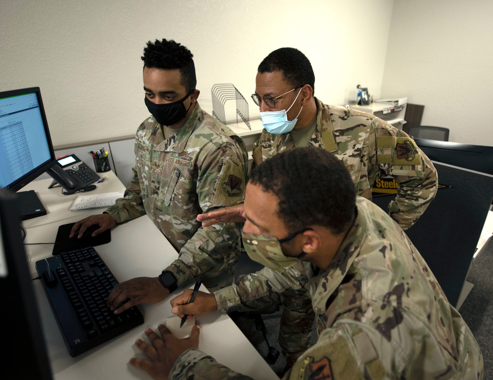 Airmen work at computer