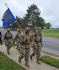 U.S. Air Force Master Sgt. Kade Forrester, 11th Contracting Squadron Infrastructure Flight section chief, holds the unit guidon during a ruck march at Joint Base Anacostia-Bolling, Washington, D.C., May 12, 2021. He was nominated in the senior enlisted category for the 2021 Lance P. Sijan United States Air Force Leadership Award by the 11th Wing, Joint Base Anacostia-Bolling, Washington, D.C. The wing nominated four of its Airmen for the award, with each competing at the Air Force District of Washington direct-reporting unit and major command level. Each year, one senior officer, one junior officer, one senior enlisted and one junior enlisted member earns the award for exceptional leadership traits in mission accomplishment or overcoming unique problems and emergencies, ability to inspire others and demonstrate eagerness to assist in goal accomplishment, and involvement in their local community. (U.S. Air Force photo by Tech. Sgt. Corey Hook)