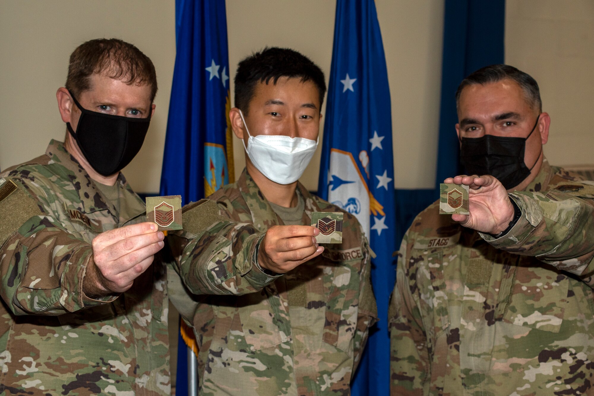 Three men in Air Force uniforms display their rank insignias.