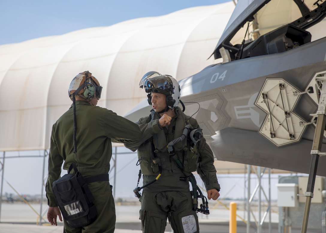 U.S. Marine Corps Lt. Col. Alexander Goodno, commanding officer of Marine Fighter Attack Squadron (VMFA) 225, greets another Marine during his final checks, before boarding his jet at Marine Corps Air Station Yuma, Ariz., September 25, 2021.