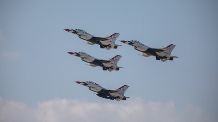Four Air Force Thunderbird jets fly in formation upwards