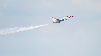 Single Air Force Thunderbird jet ascends into the clouds