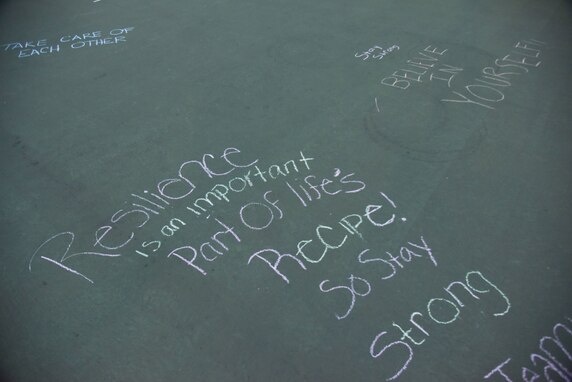 Encouraging messages are written with chalk on a physical training pad.