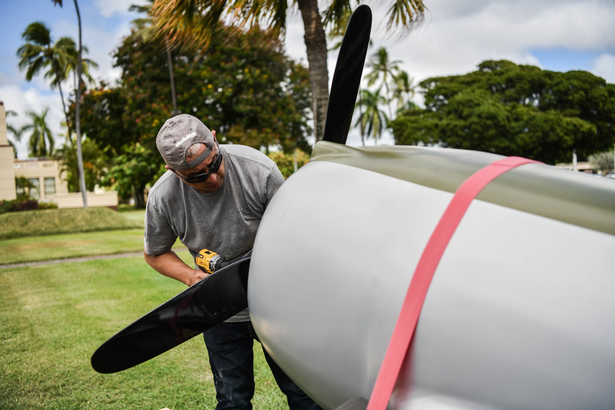 Gino Galvez, civilian contractor, attaches a propeller to a half-scale model of a Curtiss P-36A Hawk at Joint Base Pearl Harbor-Hickam, Hawaii, Sept. 29, 2021. During the attack on Pearl Harbor, the P-36 was piloted by U.S. Army Air Corps 2nd Lt. Phillip Rasmussen, who survived and landed his heavily damaged aircraft containing 500 bullet holes. (U.S. Air Force photo by Senior Airman Alan Ricker)