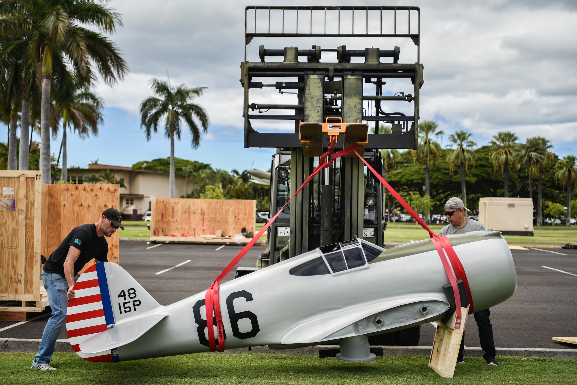 Roger Jarman and Gino Galvez, civilian contractors, guide Master Sgt. Michael Depue, 15th Maintenance Squadron maintenance flight chief, as he relocates a half-scale model of a Curtiss P-36A Hawk at Joint Base Pearl Harbor-Hickam, Hawaii, Sept. 29, 2021. This aircraft was flown during the attack on Pearl Harbor by U.S. Army Air Corps 2nd Lt. Phillip Rasmussen, who received the Silver Star for his actions on Dec. 7, 1941. (U.S. Air Force photo by Senior Airman Alan Ricker)