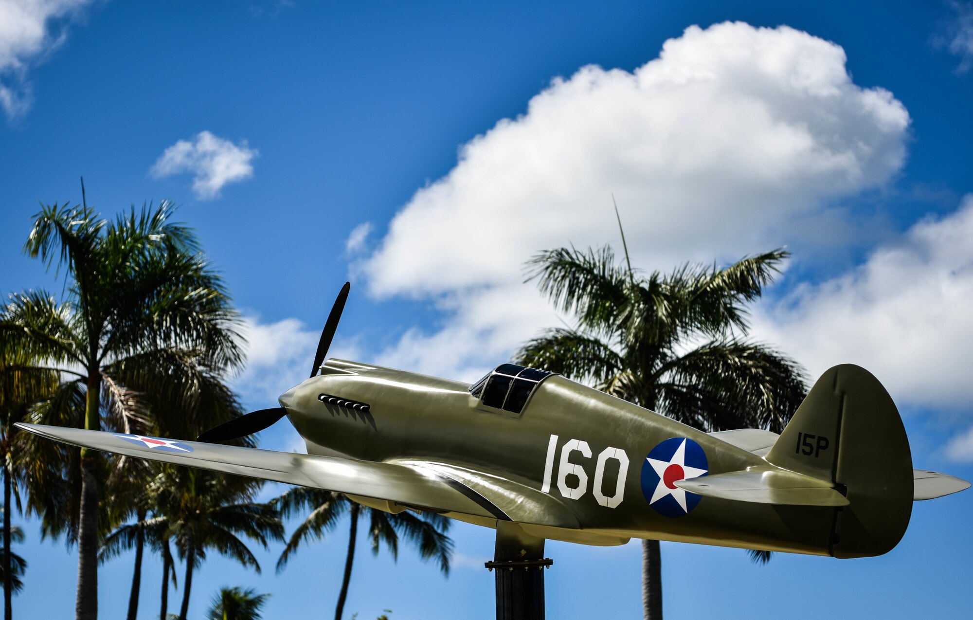 A half-scale model of a P-40B Warhawk is displayed outside of the 15th Wing Headquarters building at Joint Base Pearl Harbor-Hickam, Hawaii, Sept. 29, 2021. This aircraft was flown during the attack on Pearl Harbor by U.S. Army Air Corps 2nd Lt. George S. Welch, who received the Distinguished Service Cross for his actions on Dec. 7, 1941. (U.S. Air Force photo by Senior Airman Alan Ricker)