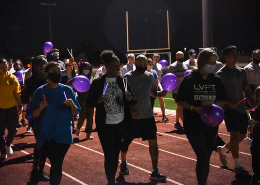 Goodfellow members walk with glow stick in the air during the Suicide Awareness 24-Hour Run/Walk on Goodfellow Air Force Base.