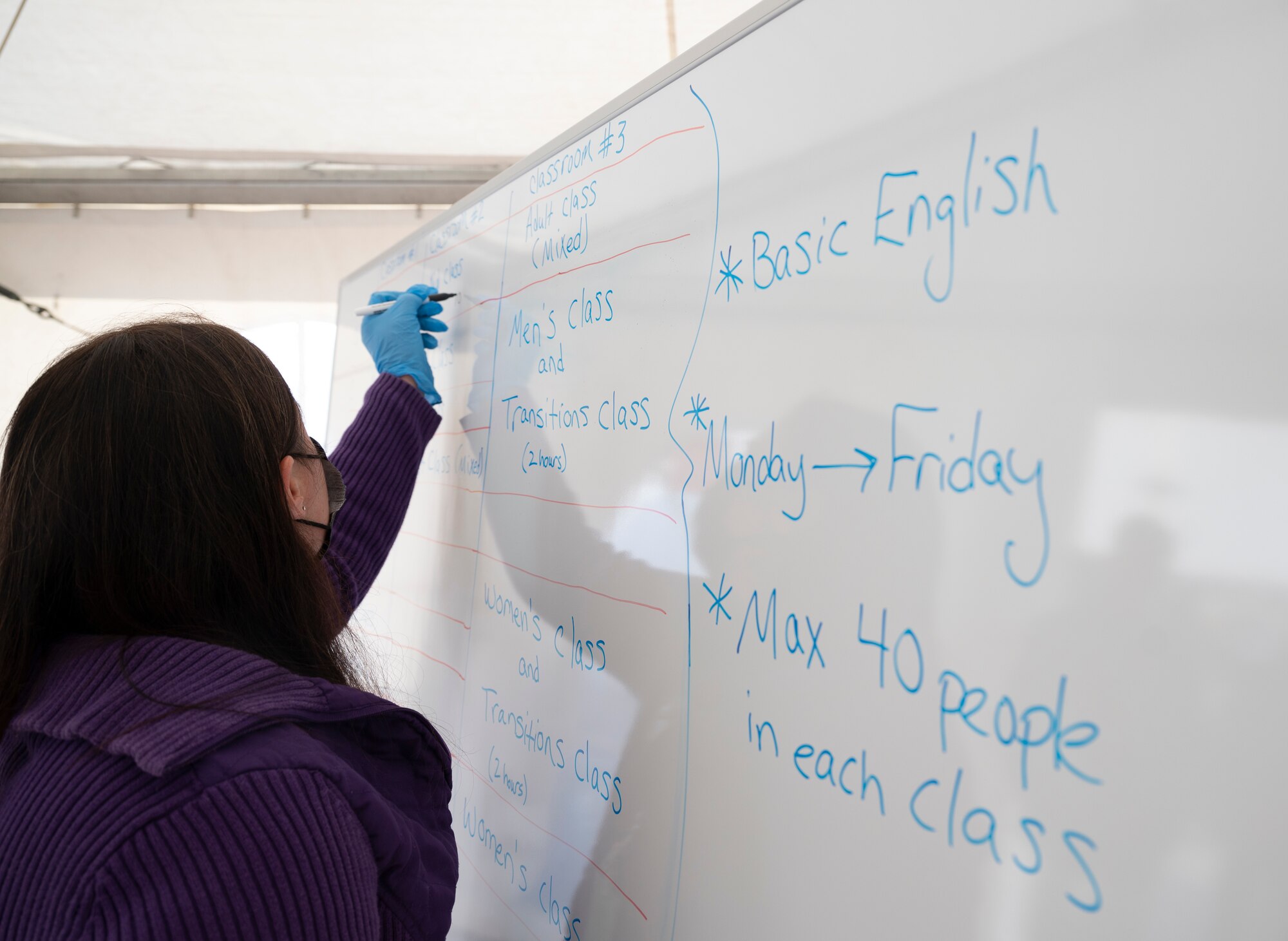 Lindsay Vanbillard, Pod two education program coordinator, writes a list of workshops being taught at Ramstein Air Base, Germany, Sept. 30, 2021. Lindsay and other instructors are teaching evacuees basic lessons in order to ensure they can adjust to culture changes when they move to the U.S. (U.S. Air Force photo by Senior Airman Thomas Karol)