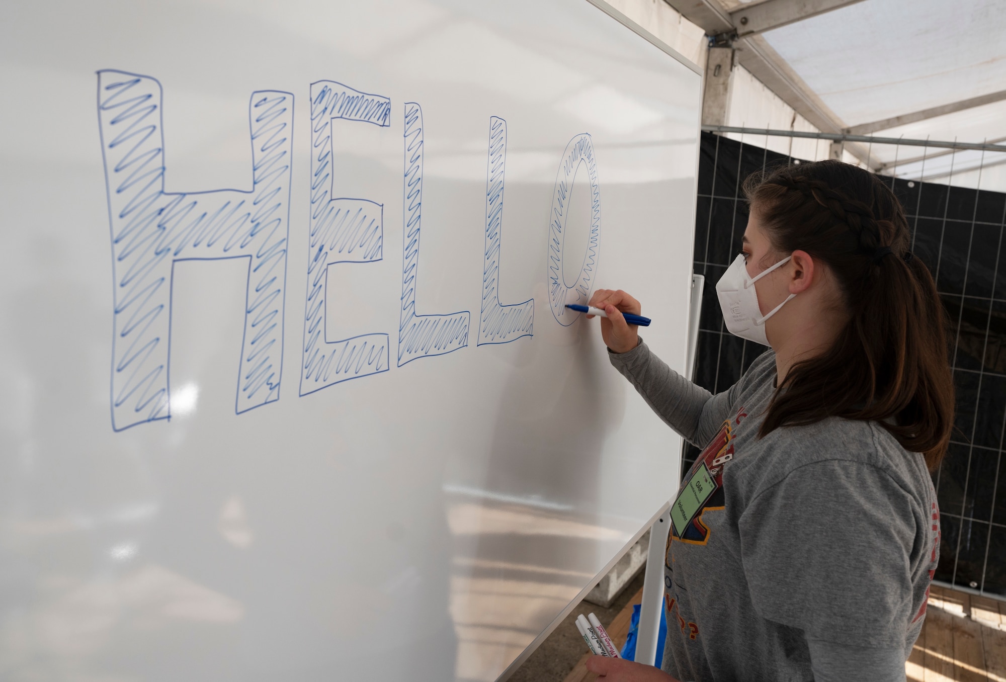 Madison Ilic, a transition class workshop instructor, writes on a white board at Ramstein Air Base, Germany, Sept. 30, 2021. Ilic and others have volunteered their time to teach evacuees from Afghanistan lessons on basic English and classroom etiquette. (U.S. Air Force photo by Senior Airman Thomas Karol)